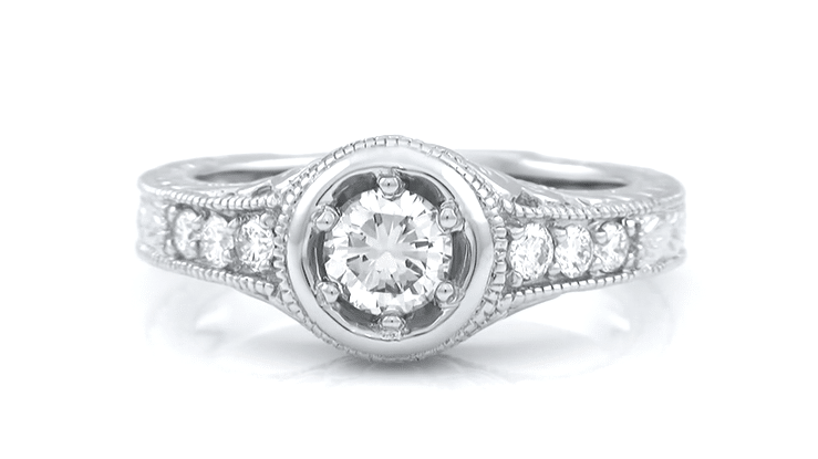 This White Gold Art Deco low profile ring setting for a 1/2 carat round diamond has a high polish halo circle around the center diamond and side diamonds on the top of the band - 3 stones on each side of the center diamond. Filigree under the setting and engraving down the sides of the ring is shown. R990W50NS
