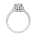 An ornate white gold white sapphire engagement ring with a filigree setting, patterned shank and a round-cut white sapphire center stone, shown on the side against a plain white background. R180W33WS