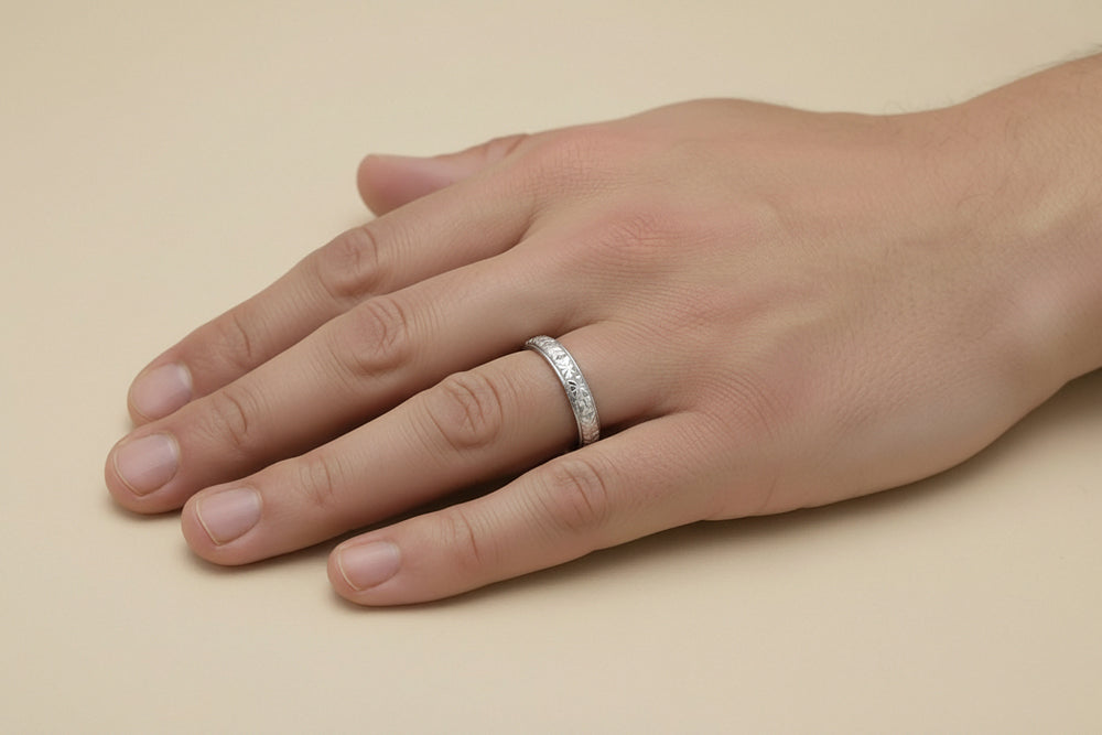 Man hand with a 3.5mm wide 1920s antique Art Deco wedding band in platinum with a carved floral pattern - R853P.