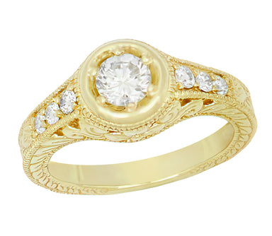 A low profile filigree Art Deco vintage yellow gold ring with a round center diamond in a halo setting with six smaller accent stones on the shoulders, with a carved wheat design on the band, set against a plain white background. R990Y50D