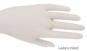 A gold band ring displayed on a mannequin hand labeled 'Ladie's Hand' against a plain white background.