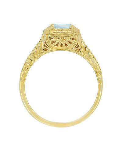 Side view of a vintage Art Deco ornate yellow gold filigree ring featuring a round light blue aquamarine gemstone at the center, shown against a plain white background. R183YA