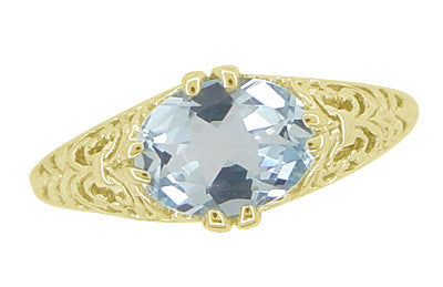 An Edwardian filigree aquamarine ring in yellow gold with an oval sky blue natural aquamarine of 1.05 carat in an 8 prong claw setting set side to side, east to west. - R799YA